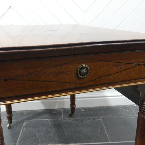 483 - A 19th century mahogany Pembroke Table, with ebony stringing raised on turned supports and brass cas... 