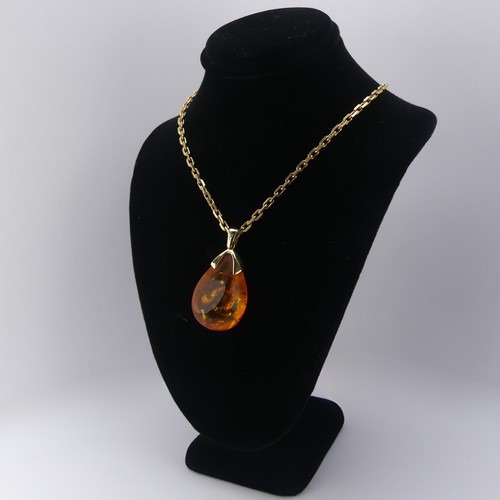 226 - A modern 9ct gold mounted amber Pendant, the reconstituted tear drop shaped stone, 3.2cm long, on a ... 