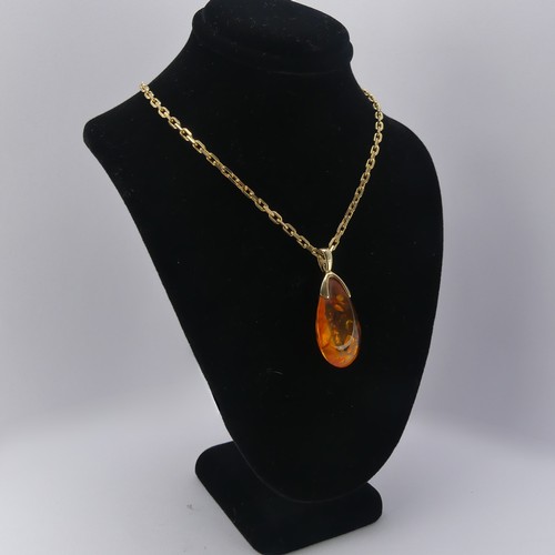 226 - A modern 9ct gold mounted amber Pendant, the reconstituted tear drop shaped stone, 3.2cm long, on a ... 