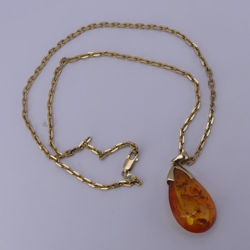 226 - A modern 9ct gold mounted amber Pendant, the reconstituted tear drop shaped stone, 3.2cm long, on a ... 