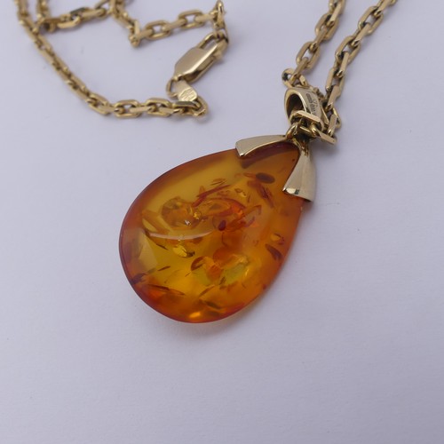 226 - A modern 9ct gold mounted amber Pendant, the reconstituted tear drop shaped stone, 3.2cm long, on a ... 