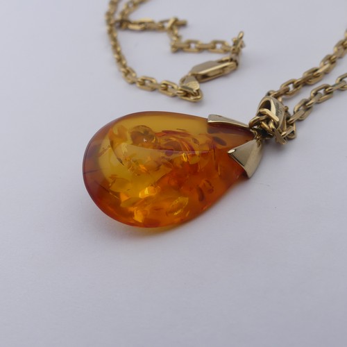 226 - A modern 9ct gold mounted amber Pendant, the reconstituted tear drop shaped stone, 3.2cm long, on a ... 