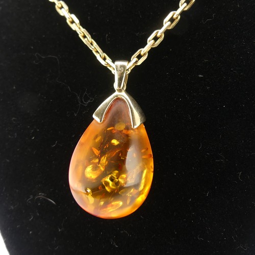 226 - A modern 9ct gold mounted amber Pendant, the reconstituted tear drop shaped stone, 3.2cm long, on a ... 