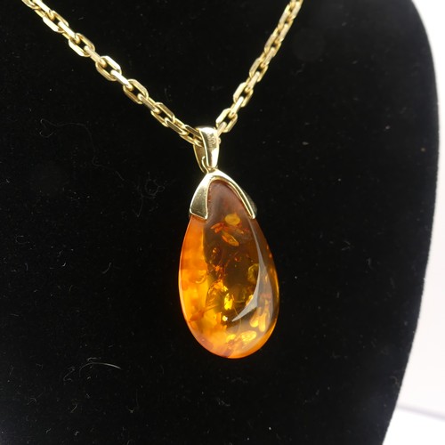 226 - A modern 9ct gold mounted amber Pendant, the reconstituted tear drop shaped stone, 3.2cm long, on a ... 