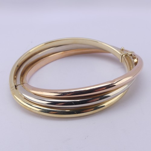 282 - A 14ct tri-colour gold hollow hinged Bangle, the snap marked 'Arpas 14k' and tested, 27.9g.... 