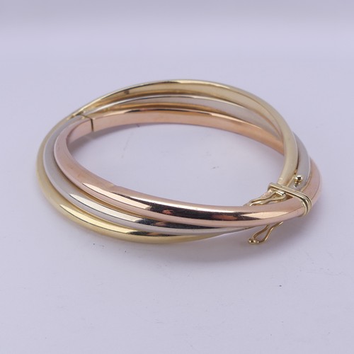 282 - A 14ct tri-colour gold hollow hinged Bangle, the snap marked 'Arpas 14k' and tested, 27.9g.... 