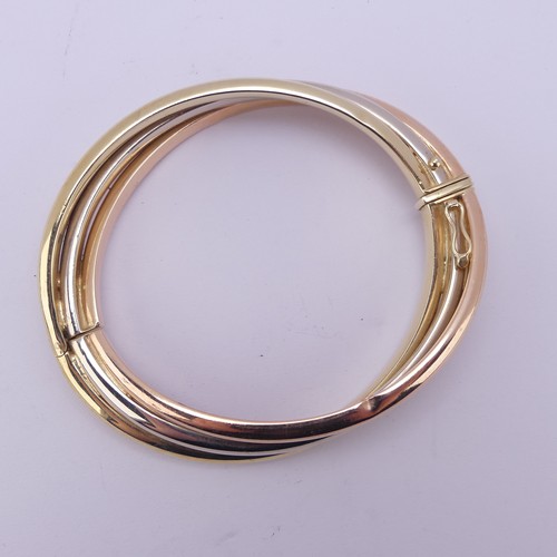 282 - A 14ct tri-colour gold hollow hinged Bangle, the snap marked 'Arpas 14k' and tested, 27.9g.... 