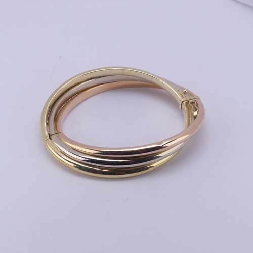 282 - A 14ct tri-colour gold hollow hinged Bangle, the snap marked 'Arpas 14k' and tested, 27.9g.... 