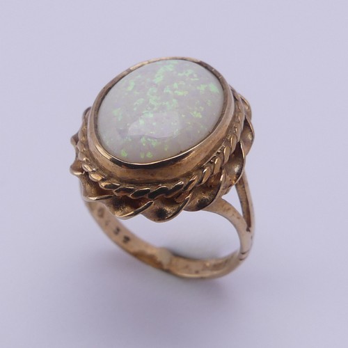 157 - A 9ct gold mounted opal Ring, the oval cabochon stone approx. 13.4mm long, in twisted mount, Size L,... 