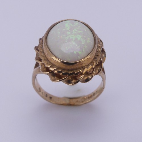 157 - A 9ct gold mounted opal Ring, the oval cabochon stone approx. 13.4mm long, in twisted mount, Size L,... 