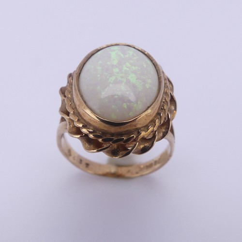 157 - A 9ct gold mounted opal Ring, the oval cabochon stone approx. 13.4mm long, in twisted mount, Size L,... 