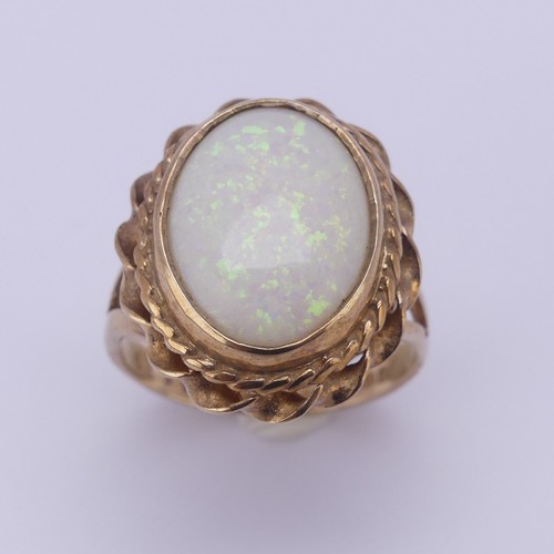 157 - A 9ct gold mounted opal Ring, the oval cabochon stone approx. 13.4mm long, in twisted mount, Size L,... 