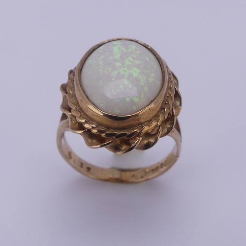 157 - A 9ct gold mounted opal Ring, the oval cabochon stone approx. 13.4mm long, in twisted mount, Size L,... 