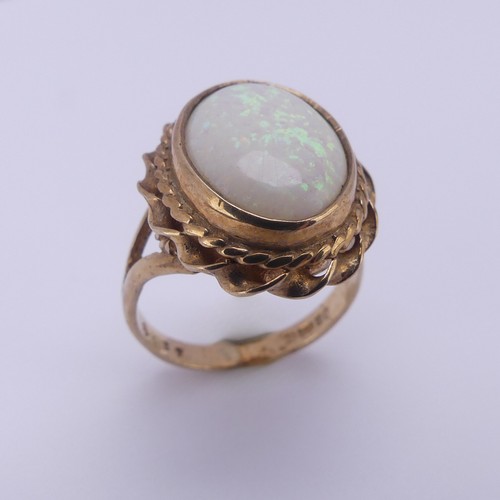 157 - A 9ct gold mounted opal Ring, the oval cabochon stone approx. 13.4mm long, in twisted mount, Size L,... 