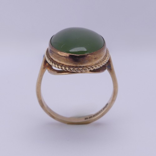 158 - A 9ct gold mounted jade Ring, the oval cabochon stone approx. 18mm long, in twist mount, Size O½, 4.... 