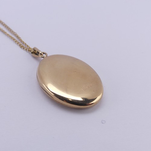 355 - A 9ct yellow gold oval hinged Locket, the front with foliate decoration, 2.6cm long, on a 9ct gold f... 