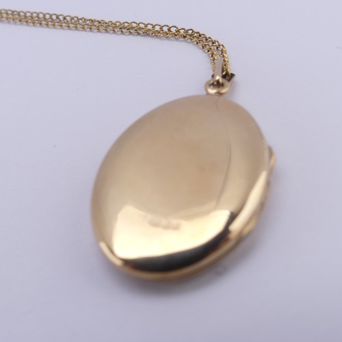 355 - A 9ct yellow gold oval hinged Locket, the front with foliate decoration, 2.6cm long, on a 9ct gold f... 