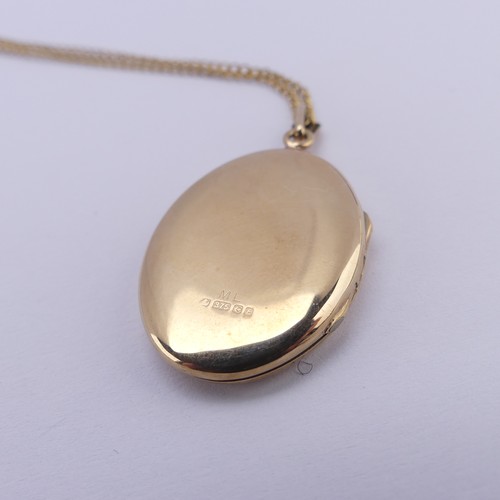 355 - A 9ct yellow gold oval hinged Locket, the front with foliate decoration, 2.6cm long, on a 9ct gold f... 