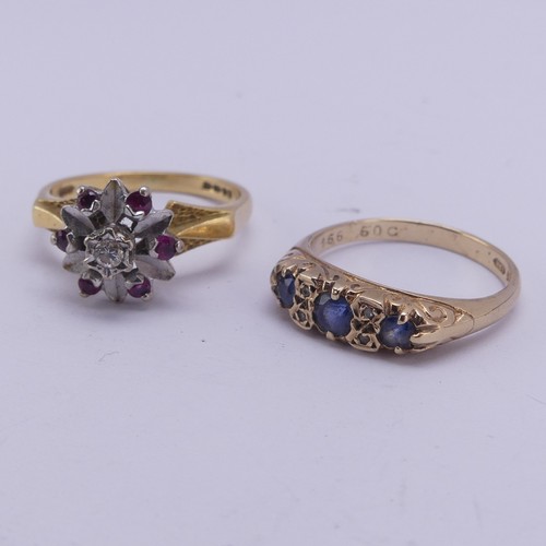 165 - A three stone sapphire Ring, the graduated stones with two vertically set diamond points between eac... 