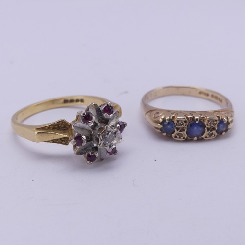 165 - A three stone sapphire Ring, the graduated stones with two vertically set diamond points between eac... 