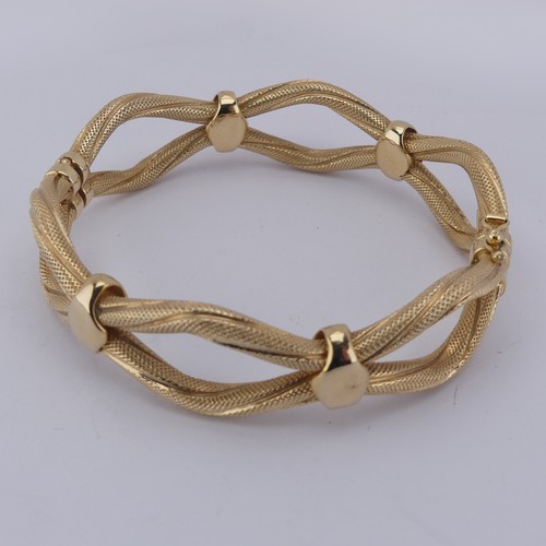 289 - A 9ct yellow gold hollow hinged Bangle, the two textured wavy strands joined with polished loops, sp... 