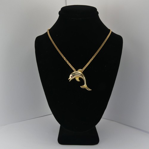 261 - A 14ct yellow gold Dolphin Pendant, with ruby eye, 3.3cm wide, 4.3g, on a 9ct gold curb link chain, ... 