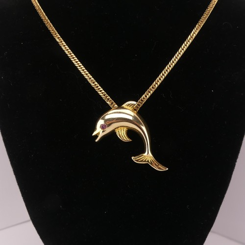 261 - A 14ct yellow gold Dolphin Pendant, with ruby eye, 3.3cm wide, 4.3g, on a 9ct gold curb link chain, ... 