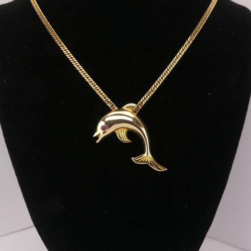 261 - A 14ct yellow gold Dolphin Pendant, with ruby eye, 3.3cm wide, 4.3g, on a 9ct gold curb link chain, ... 