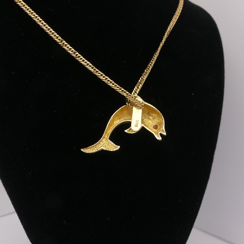 261 - A 14ct yellow gold Dolphin Pendant, with ruby eye, 3.3cm wide, 4.3g, on a 9ct gold curb link chain, ... 