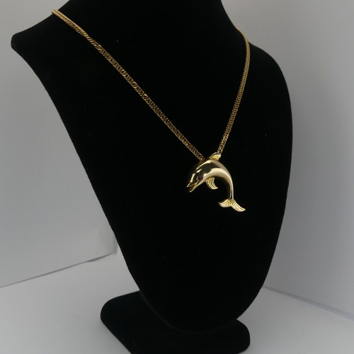 261 - A 14ct yellow gold Dolphin Pendant, with ruby eye, 3.3cm wide, 4.3g, on a 9ct gold curb link chain, ... 