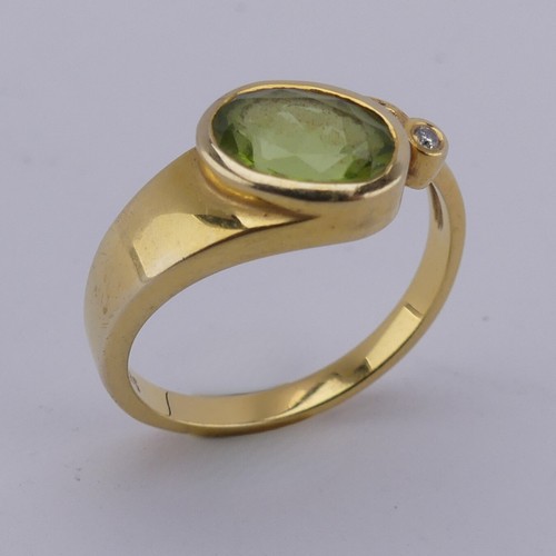 169 - An oval facetted peridot Ring, collet set in 14ct yellow gold with diamond point accent, Size M, 3.3... 