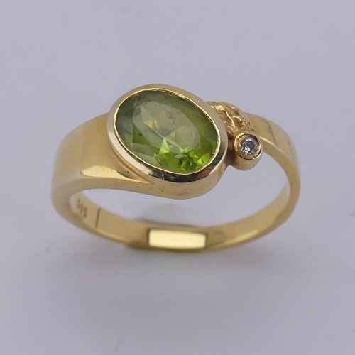 169 - An oval facetted peridot Ring, collet set in 14ct yellow gold with diamond point accent, Size M, 3.3... 