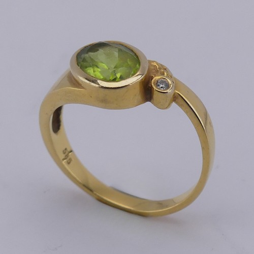 169 - An oval facetted peridot Ring, collet set in 14ct yellow gold with diamond point accent, Size M, 3.3... 