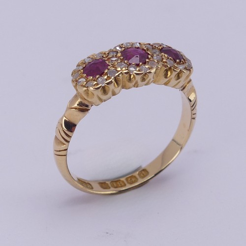 172 - An Edwardian ruby and diamond triple cluster Ring, the circular facetted rubies surrounded by rose c... 