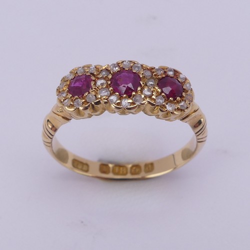 172 - An Edwardian ruby and diamond triple cluster Ring, the circular facetted rubies surrounded by rose c... 