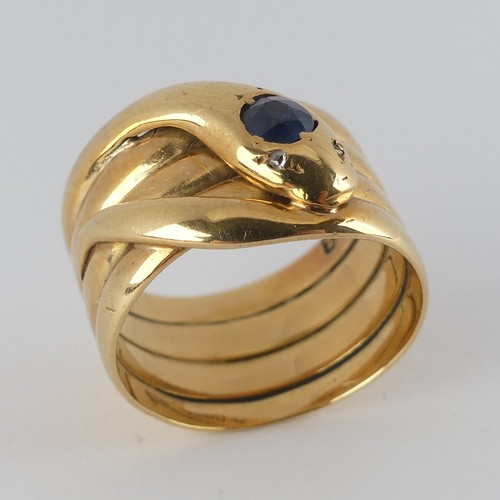 A late Victorian 18ct yellow gold coiled snake Ring, the head set with a facetted sapphire, approx. 4mm diameter, and with single cut diamond eyes, hallmarked Birmingham 1899, makers mark 'NBs', 12.5mm wide, Size Q, 11.4g.