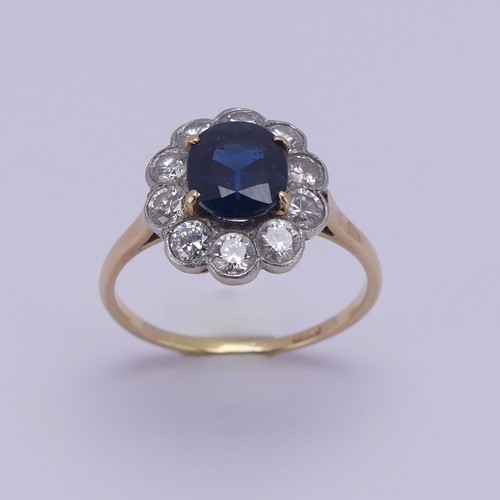 181 - A sapphire and diamond cluster Ring, the central oval facetted sapphire approx. 7.6mm x 6.4mm, surro... 