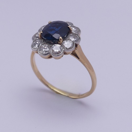 181 - A sapphire and diamond cluster Ring, the central oval facetted sapphire approx. 7.6mm x 6.4mm, surro... 