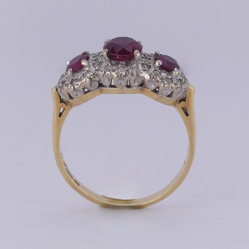 182 - A ruby and diamond triple cluster Ring, the graduated circular facetted rubies surrounded by small d... 