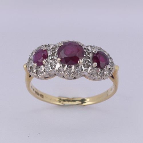 182 - A ruby and diamond triple cluster Ring, the graduated circular facetted rubies surrounded by small d... 