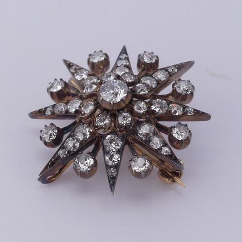 330 - A Victorian diamond star Pendant / Brooch, the central cushion shaped old cut stone approx. 0.35ct, ... 