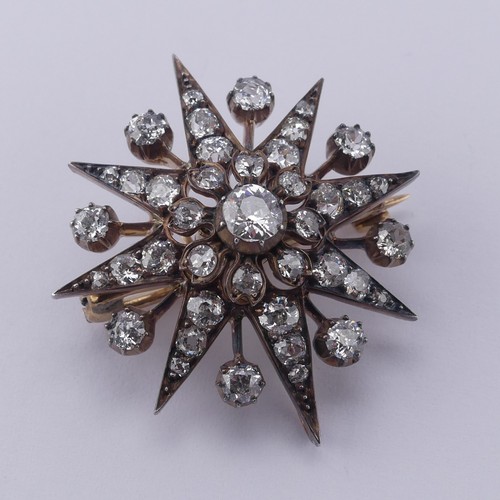 330 - A Victorian diamond star Pendant / Brooch, the central cushion shaped old cut stone approx. 0.35ct, ... 