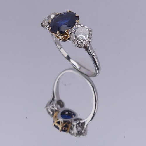 301 - A sapphire and diamond three stone Ring, the central cushion shaped facetted sapphire, approx. 2.6ct... 