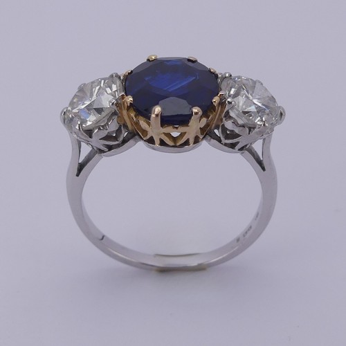 301 - A sapphire and diamond three stone Ring, the central cushion shaped facetted sapphire, approx. 2.6ct... 