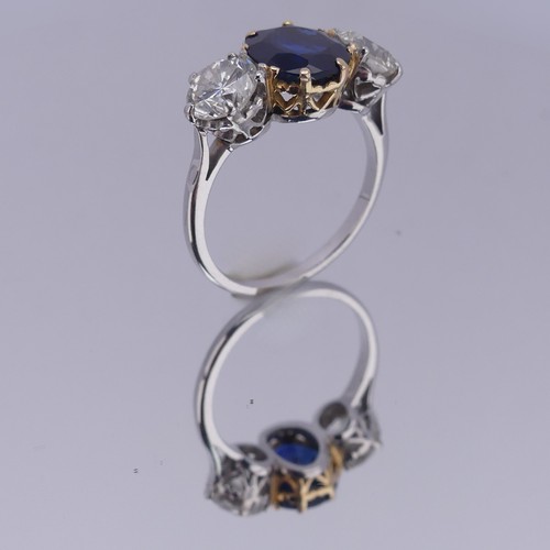 301 - A sapphire and diamond three stone Ring, the central cushion shaped facetted sapphire, approx. 2.6ct... 