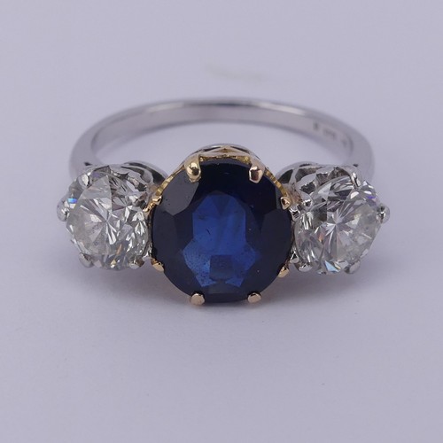 301 - A sapphire and diamond three stone Ring, the central cushion shaped facetted sapphire, approx. 2.6ct... 