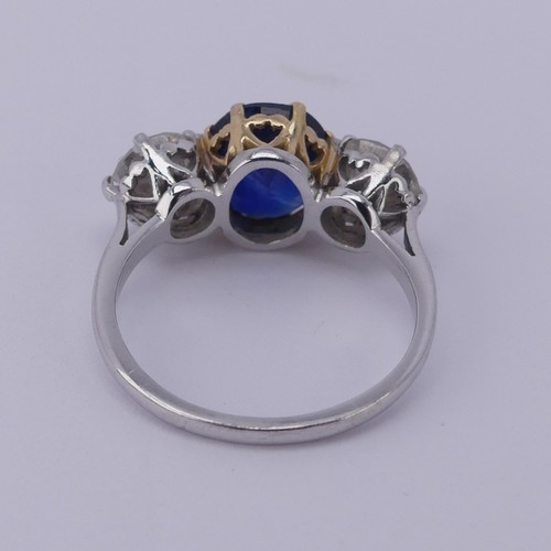 301 - A sapphire and diamond three stone Ring, the central cushion shaped facetted sapphire, approx. 2.6ct... 