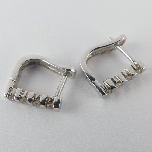 332 - A pair of 18ct white gold hoop Earrings, the fronts set with four small brilliant cut diamonds, 12mm... 