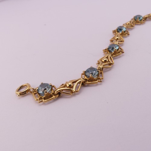 304 - A blue topaz Bracelet, the seven circular facetted stones 5.85mm diameter, four claw set in 18ct yel... 