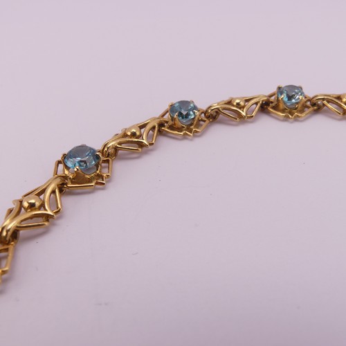 304 - A blue topaz Bracelet, the seven circular facetted stones 5.85mm diameter, four claw set in 18ct yel... 